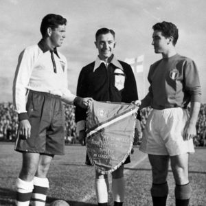 In this July 16, 1952, file photo, Harry Keough, left, captain of the U.S. Olympic men's soccer team, greets Italy's captain, E. Pandolfini, right, and referee A.E. Ellis, of Great Britain, prior to the start of their match in Tampere, Finland.