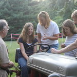 Dad, Carol, Kim and Bill teaching Amy to drive the Ford tractor, 2010.