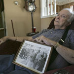 Elwin Hope Wilson holds a framed photo he kept showing a mob he participated in during one of local civil rights "sit-ins" that took place in the early 1960s, as he sits at home Wednesday, March 4, 2009, in Rock Hill, S.C. Several of the clocks he collects are in the background. Elwin Wilson