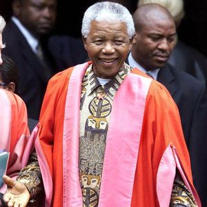 Former South Africa President Nelson Mandela smiles Wednesday, 5/2/01, before a ceremony at Magdalene College, Cambridge, England, where he was being made an Honorary Fellow. Around 100 students and staff had gathered to welcome Mandela and he donned the robes of a Doctor of Law of Cambridge University